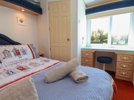 A bedroom with a bed and desk at Mor a Mynydd Pwllheli