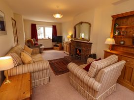 A living room with a sofa and television at Sarah's Cottage