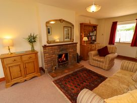A living room with a fireplace and mirror at Sarah's Cottage