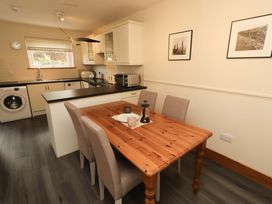 A kitchen with a dining table and appliances at Sarah's Cottage