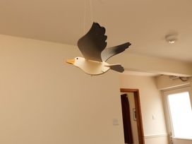 A bird decoration hanging from the ceiling in a living room at Sarah's Cottage