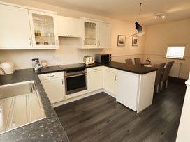 A kitchen with appliances and seating at Sarah's Cottage