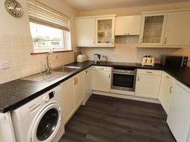 A kitchen with appliances and cabinets at Sarah's Cottage