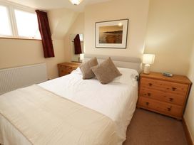 A bedroom with a bed and nightstand at Sarah's Cottage