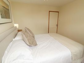 A bedroom with a bed and lamp at Sarah's Cottage