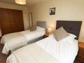 A bedroom with two beds and a lamp at Sarah's Cottage in 