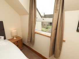 A bedroom with a bed and a window at Sarah's Cottage