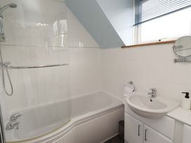 A bathroom with a bathtub and sink at Sarah's Cottage