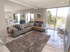 A living room with a sofa and a dining area at Midways, Windermere