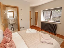 A bedroom with a bed and wash basin at Midways Windermere