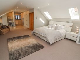A bedroom with a bed and sofa at Midways in Windermere