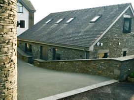 An exterior view of a house with stone walls and a driveway at Midways in Windermere