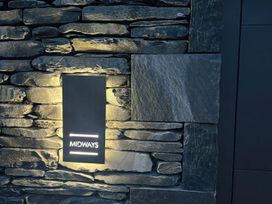 A wall with a lit sign at Midways in Windermere