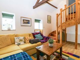 A living room with stairs and a sofa at Ty Loti