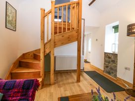 A hallway with a staircase and a radiator at Ty Loti 