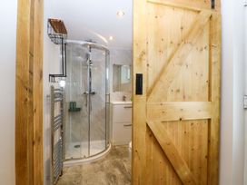 A bathroom with a shower, sink, and towel rack at Ty Loti