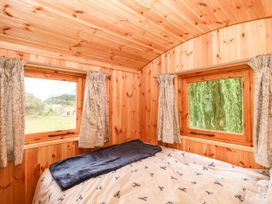 A bedroom with wooden walls and windows at Laurel in Welney near Littleport