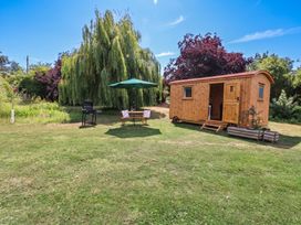 An outdoor setting with a wooden shed and seating area at Laurel in Welney near Littleport