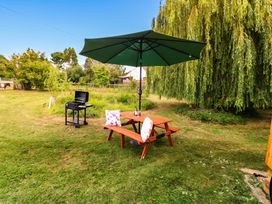 A garden with a table and grill under an umbrella at Laurel in Welney near Littleport