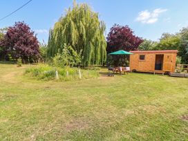 A garden with a wooden shed, table, and chair at Laurel near Littleport