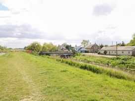A path beside a waterway with houses and a bridge at Laurel in Littleport