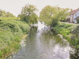 A view of a river with trees and a house at Laurel in Littleport