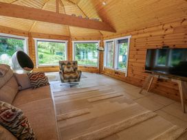 A snug with a television and seating area at Bull Rush Cabin in Carwinley near Longtown