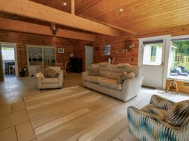 A living room with furniture including a sofa and armchairs at Bull Rush Cabin Carwinley near Longtown