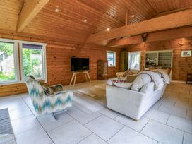 A living room with a sofa and television at Bull Rush Cabin near Longtown