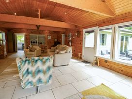 A living room with seating and tables at Bull Rush Cabin in Carwinley near Longtown