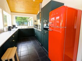 A kitchen with a red refrigerator and appliances at Bull Rush Cabin Carwinley near Longtown