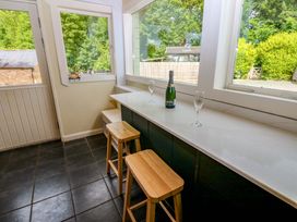 A kitchen with bar stools and champagne on the counter at Bull Rush Cabin Carwinley near Longtown