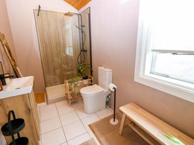 A bathroom with a shower, toilet, and sink at Bull Rush Cabin Carwinley near Longtown