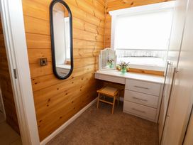 A dressing room with a mirror and a table at Bull Rush Cabin Carwinley near Longtown