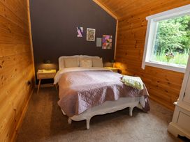 A bedroom with a bed and nightstands at Bull Rush Cabin in Carwinley near Longtown