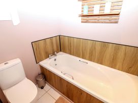 A bathroom with a bathtub and toilet at Bull Rush Cabin in Carwinley near Longtown
