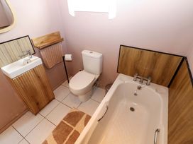 A bathroom with a bathtub and sink at Bull Rush Cabin, Carwinley near Longtown