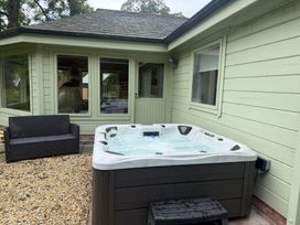 An outdoor area with a hot tub and a sofa at Bulrush Cabin Carwinley near Longtown