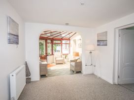 A conservatory with seating and a view of the garden at Bryn Llifon in Pentraeth
