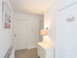 A hallway with a lamp and chest of drawers at Bryn Llifon in Pentraeth