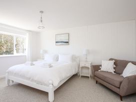 A bedroom with a bed and a sofa at Bryn Llifon in Pentraeth