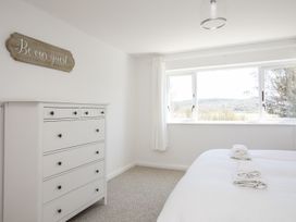 A bedroom with a dresser and bed at Bryn Llifon in Pentraeth