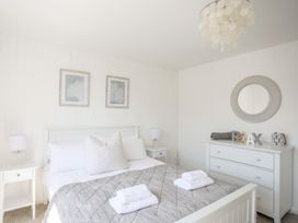 A bedroom with a bed and dresser at Bryn Llifon in Pentraeth