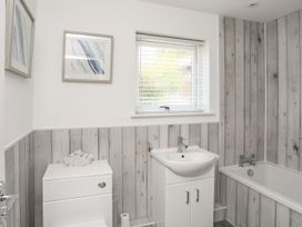 A bathroom with a sink, toilet and bathtub at Bryn Llifon in Pentraeth