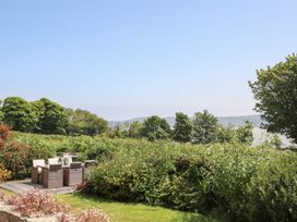 A garden with patio furniture and trees at Bryn Llifon in Pentraeth
