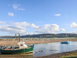 A fishing boat and a sailboat on the water at Bryn Llifon in Pentraeth