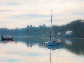A sailboat and a fishing boat on water at Bryn Llifon in Pentraeth