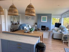 A living room with a sofa and a television at Red Wharf Retreat near Red Wharf Bay