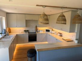 A kitchen with cabinets and countertop at Red Wharf Retreat near Red Wharf Bay