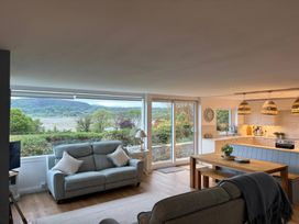 A living room with a sofa and dining table at Red Wharf Retreat near Red Wharf Bay
